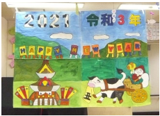 ポスターです。模造紙に「2021」「HAPPY NEW YEAR」という文字とともに、山を牛車が通っていくイラストが描かれています。