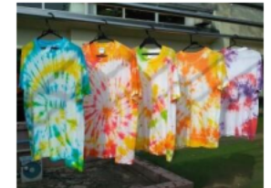 カラフルな色に染まったTシャツが5枚、物干し竿にハンガーでかけられています。